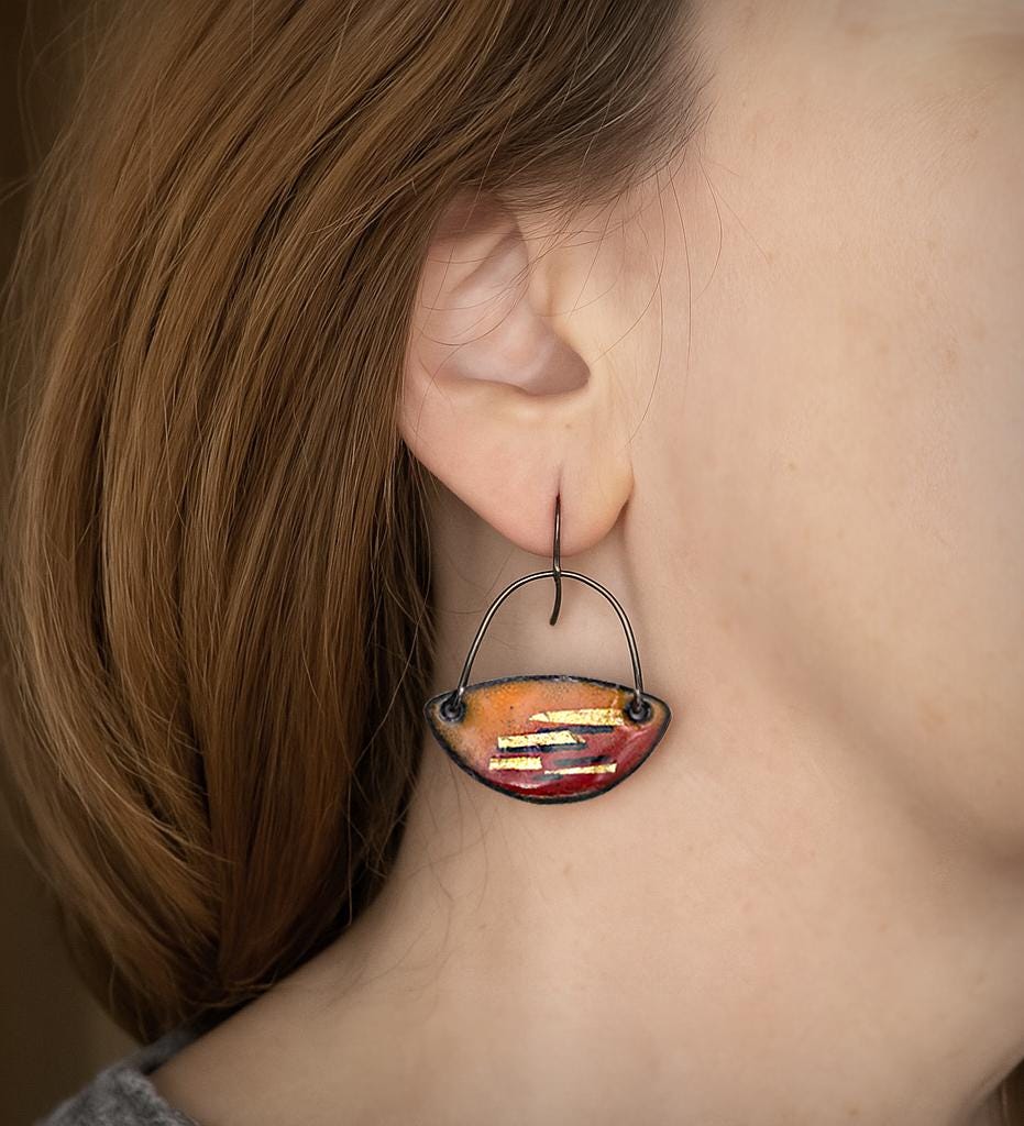 Enamel dangle earrings on-wear, teardrop orange-red with gold-tone stripe detail