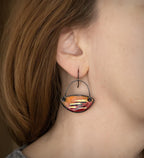 Enamel dangle earrings on-wear, teardrop orange-red with gold-tone stripe detail