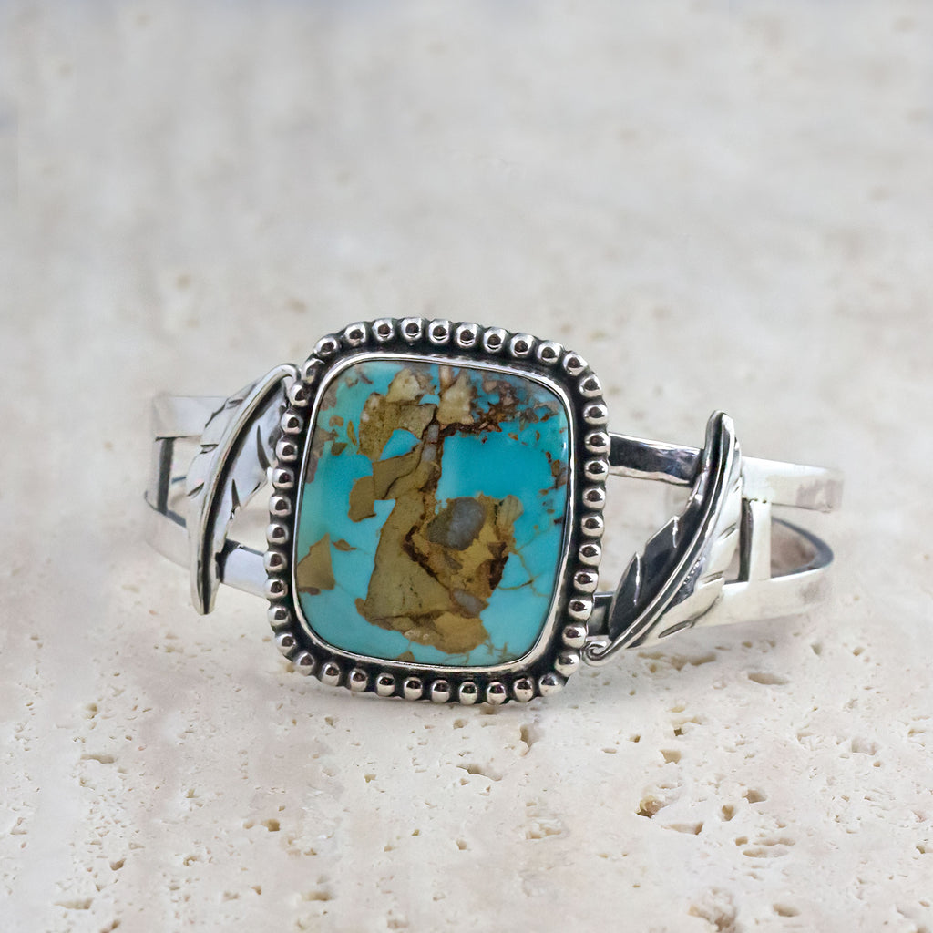 Silver cuff bracelet with turquoise oval cabochon and rope-style beaded border