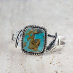 Silver cuff bracelet with turquoise oval cabochon and rope-style beaded border