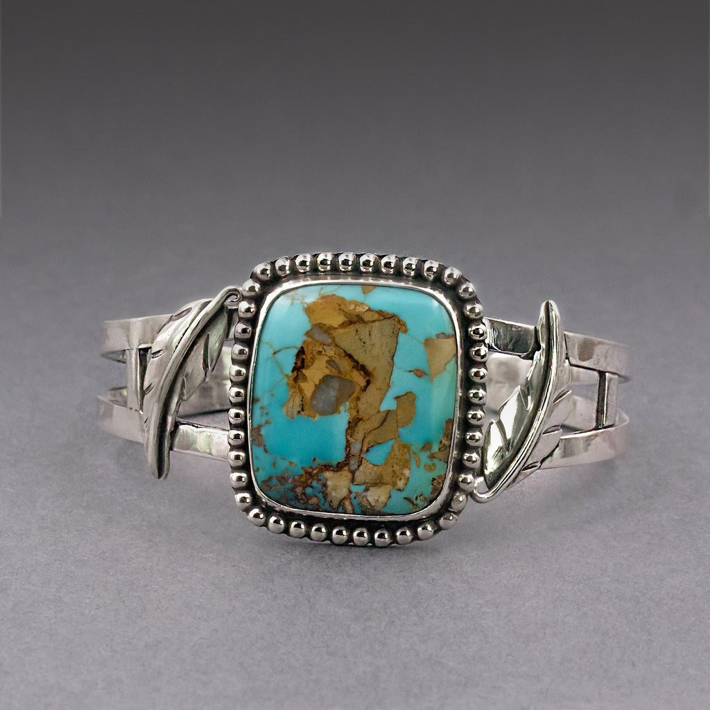Turquoise oval cabochon bracelet with silver scalloped bezel and hinged side accents