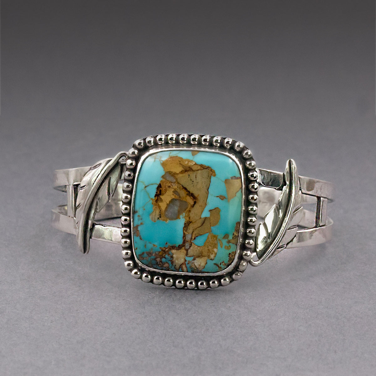 Turquoise oval cabochon bracelet with silver scalloped bezel and hinged side accents
