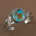 Silver-tone cuff bracelet with oval turquoise stone and textured bead bezel