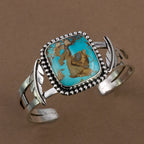 Silver-tone cuff bracelet with oval turquoise stone and textured bead bezel