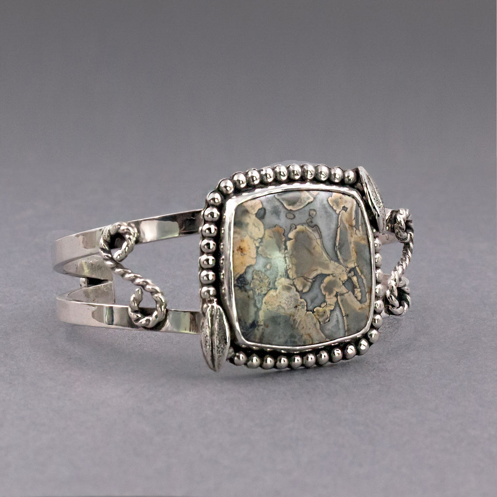 Sterling silver cuff bracelet with blue jasper square stone, bead rim and link details.