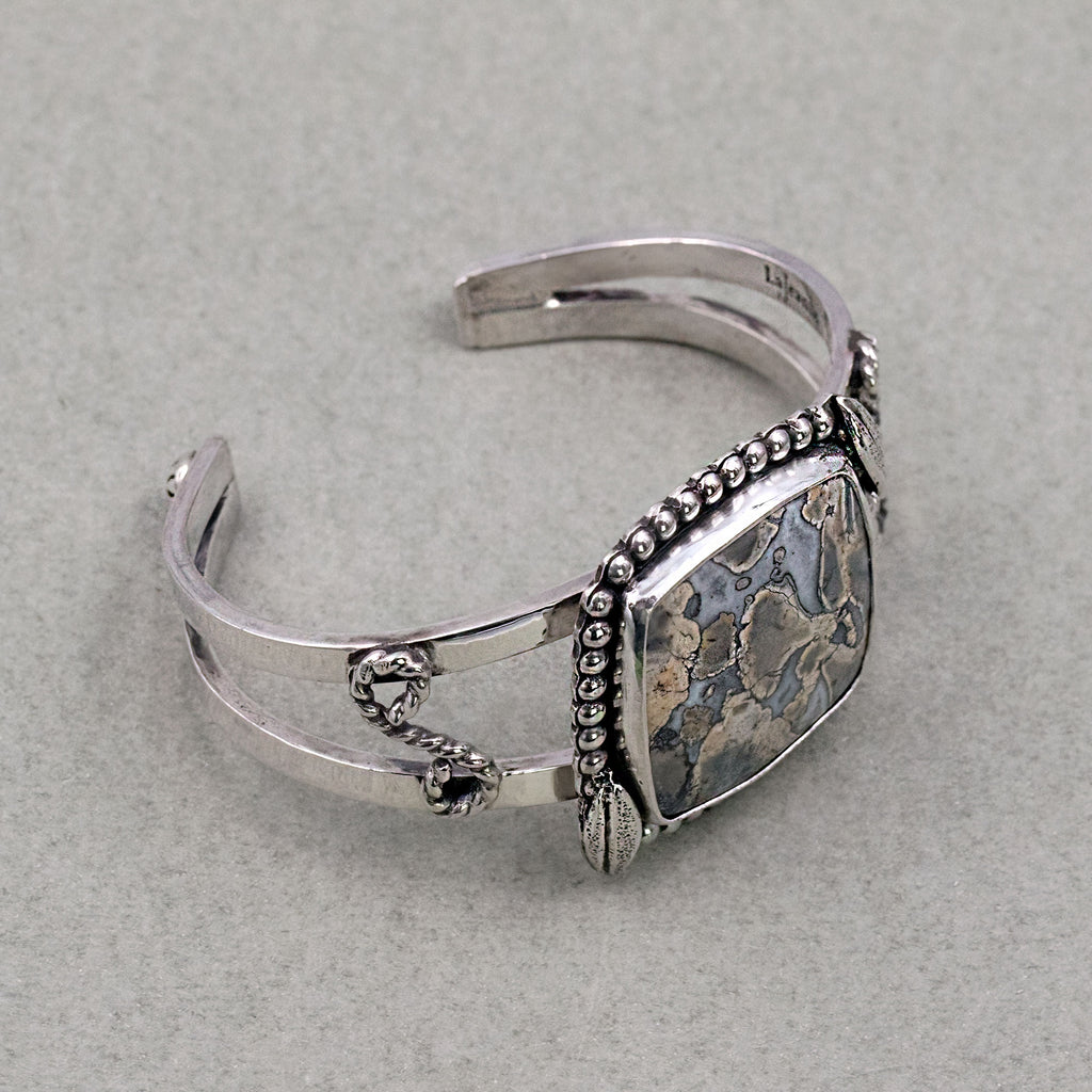 Sterling silver cuff bracelet with jasper cabochon, beaded edge and dangling chain links.