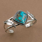 Sterling silver cuff bracelet with turquoise cushion center stone and openwork leaves