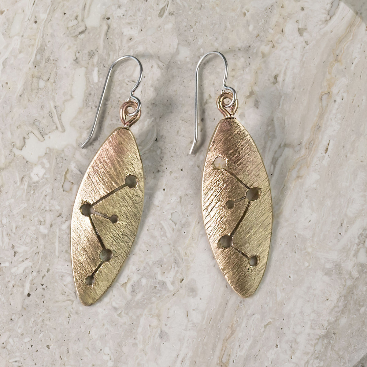 Textured brass oval dangle earrings with hammered finish and geometric dot accents