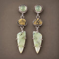 Drop earrings with pale green stones, gold-toned fossil details, and silver settings.