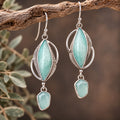 Sterling silver earrings with blue opalized wood and chalcedony stones in an ornate drop design