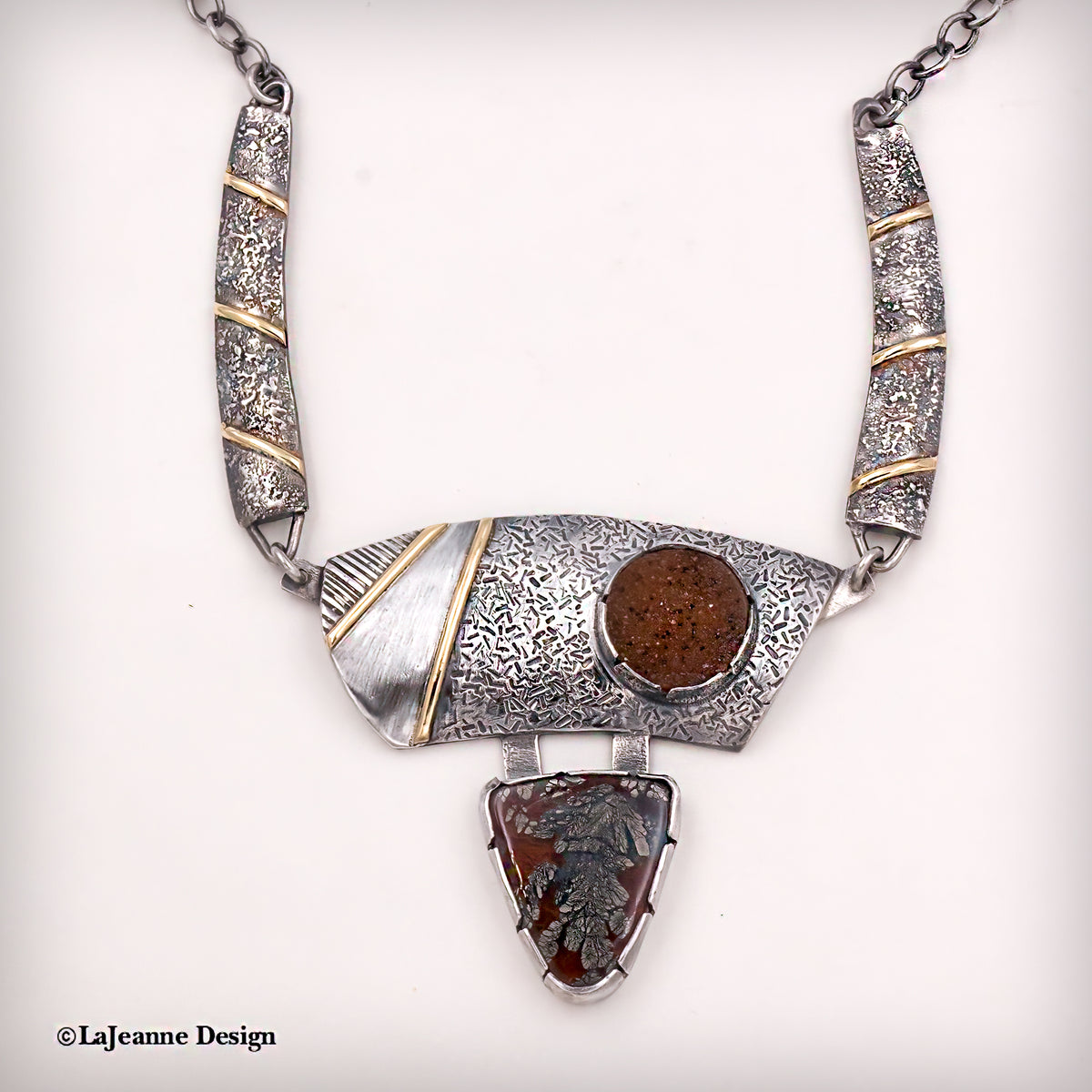 Silver statement necklace with textured stations and gold accents, round brown stone and teardrop drop