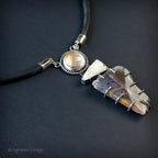 Gemstone pendant necklace with round cabochon and dark quartz cluster, black cord