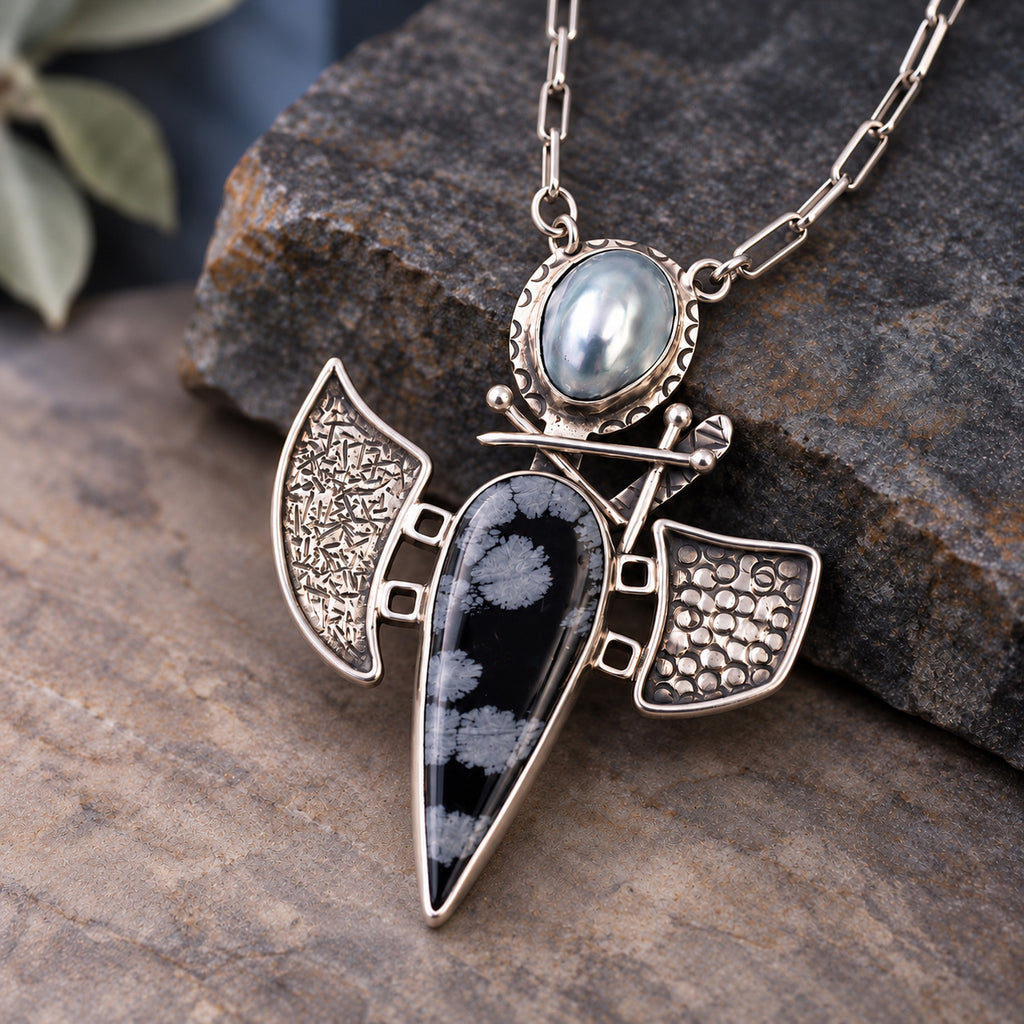 Sterling silver pendant necklace with oval pearl, black teardrop stone, and wing charms