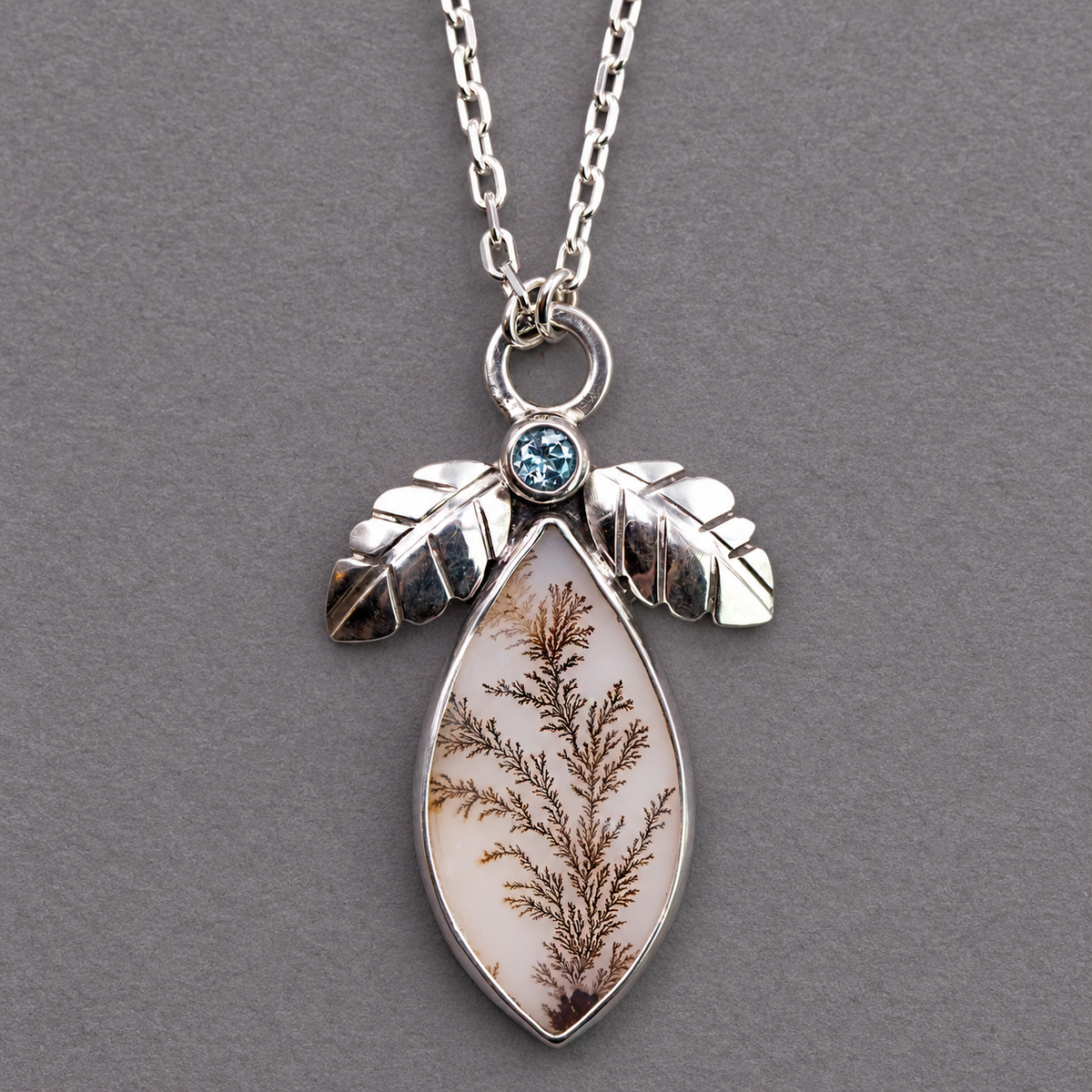 Sterling silver necklace pendant with blue topaz bezel and dendritic agate teardrop