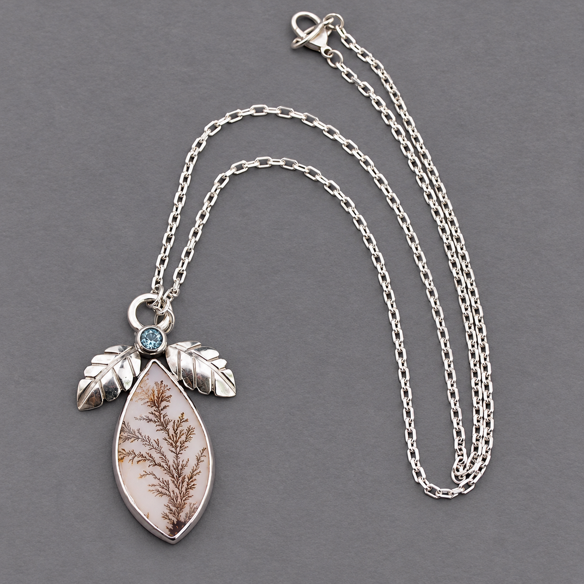 Sterling silver pendant necklace, teardrop agate with blue stone and leaflike accents