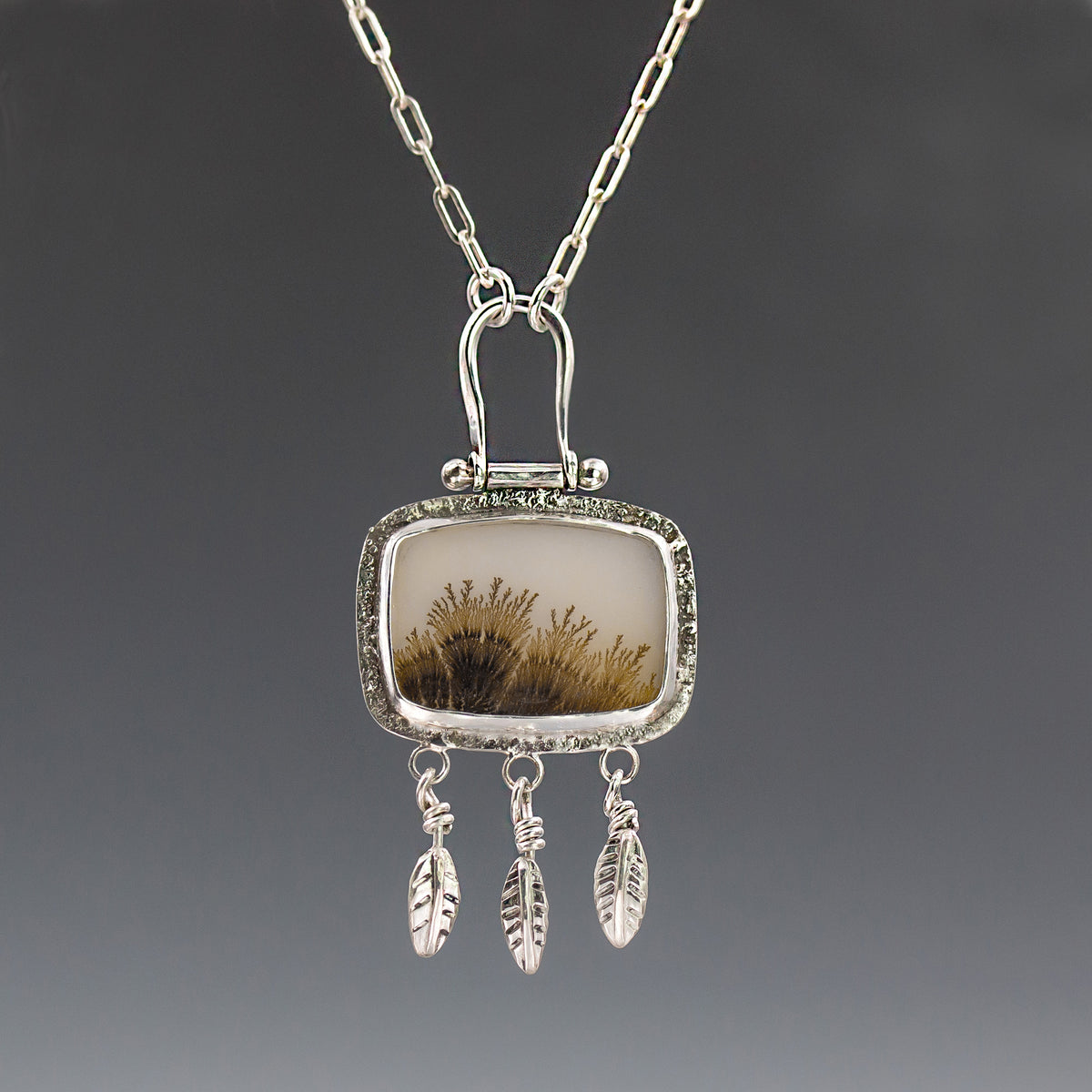 Silver necklace pendant with dendritic agate stone and dangling feather charms