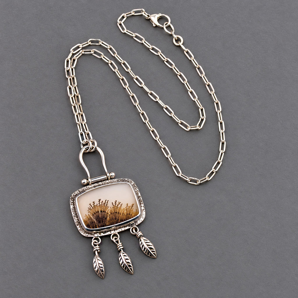 Silver chain necklace with rectangular dendritic agate pendant and three feather charms