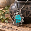 Turquoise and silver pendant necklace with ornate oval filigree setting