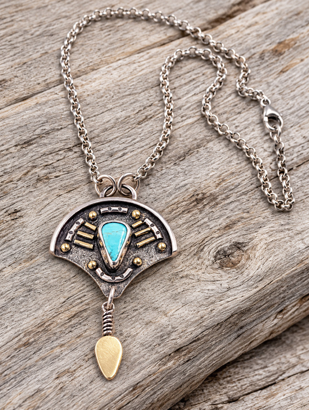 Sterling silver necklace with turquoise teardrop pendant, gold accents, and link chain