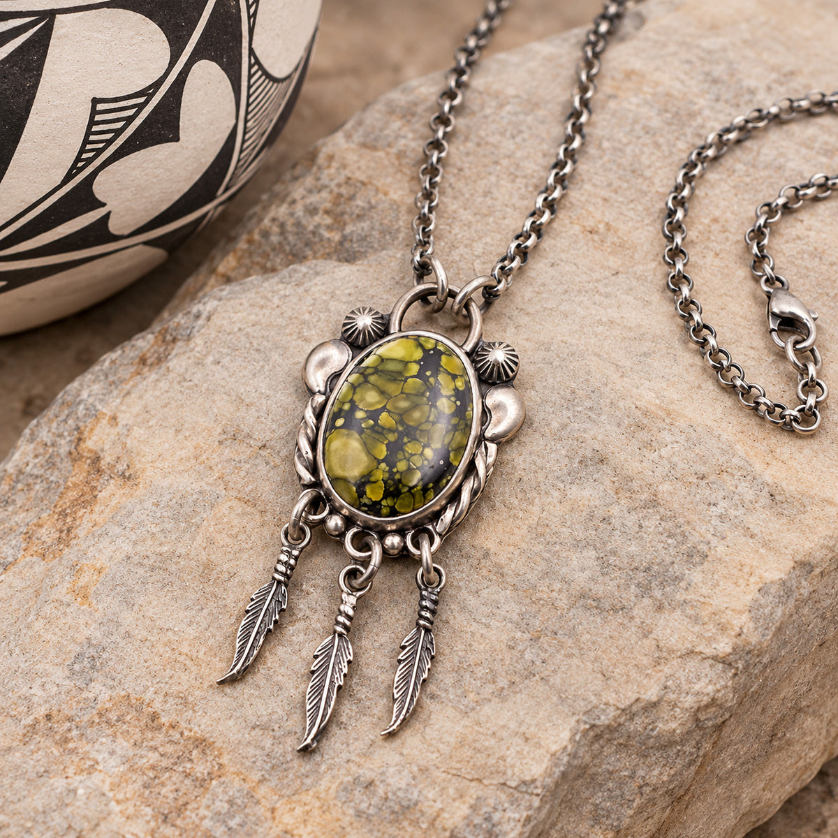 Silver-tone feather pendant necklace with oval green/yellow gemstone cabochon and chain