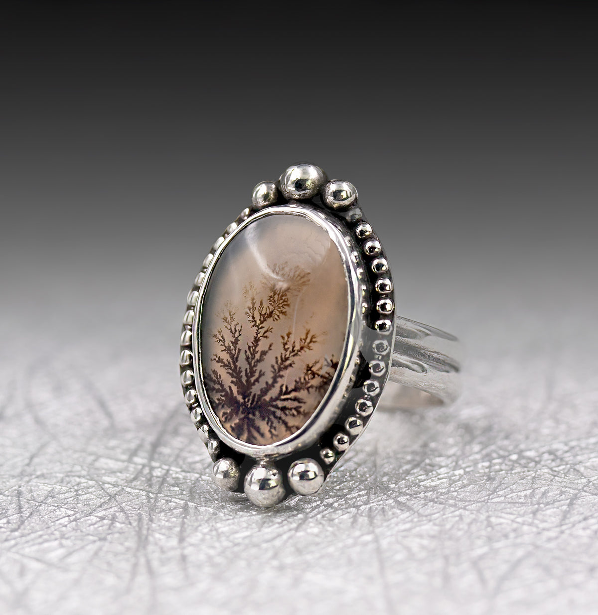 Size 7 sterling silver ring angled view of oval dendritic agate and scalloped bead setting