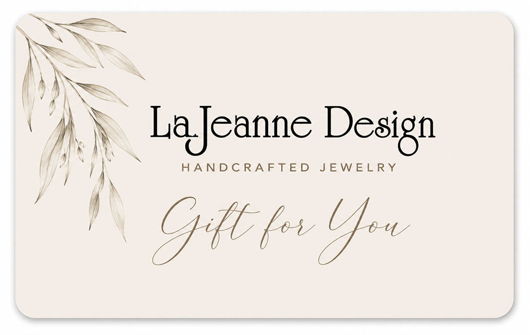 A rectangular gift card with rounded corners for LaJeanne Design, featuring a beige background, a delicate botanical leaf illustration in the upper left, and elegant black and gold typography reading 'LaJeanne Design', 'Handcrafted Jewelry', and 'Gift for You'.